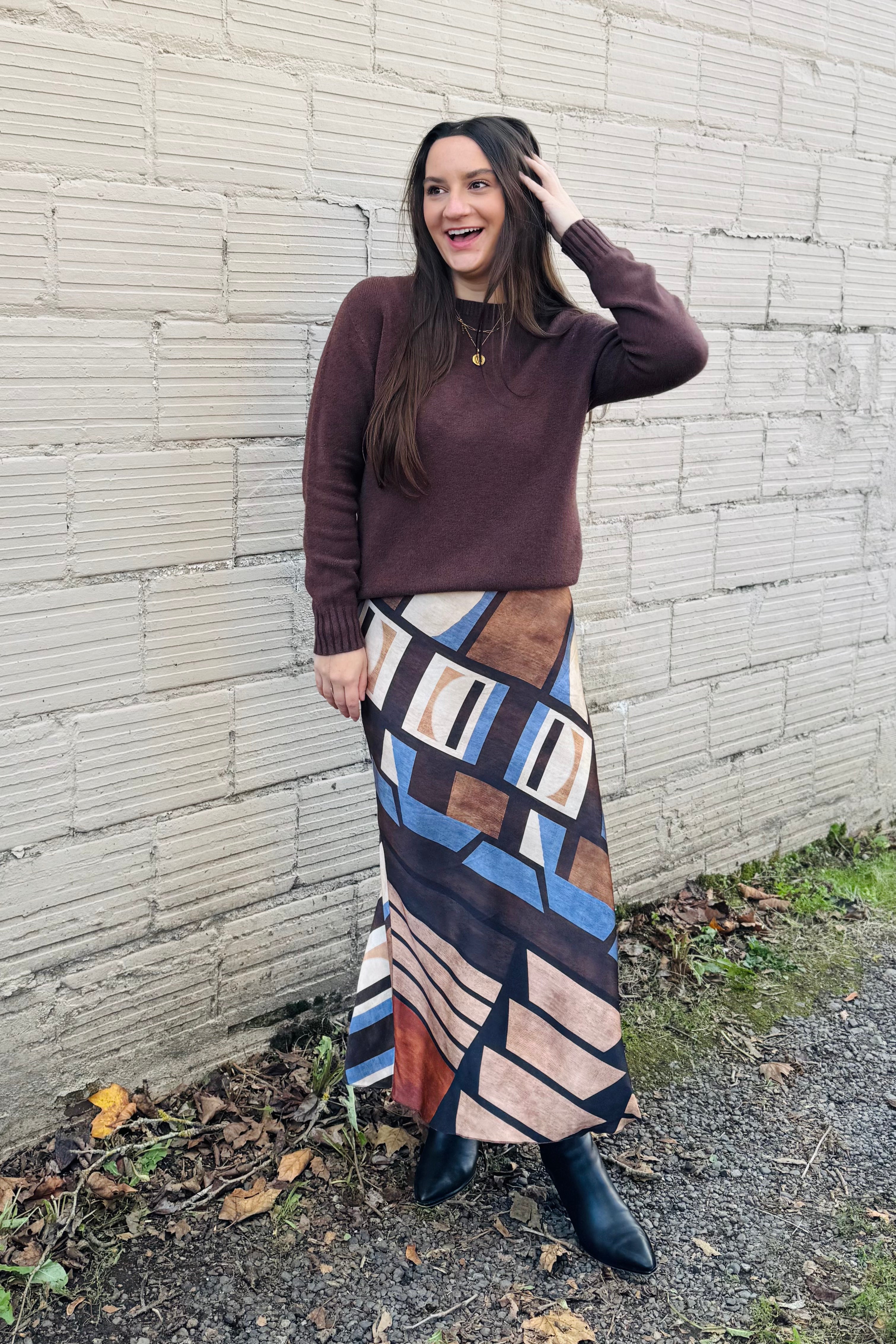 Elevate your style with this silky long skirt, featuring a striking geometric print in rich brown and blue tones. Designed to drape effortlessly, the smooth, lustrous fabric flows with every step, offering a sleek silhouette and modern edge. The geometric pattern adds a touch of wild sophistication, making this skirt a standout piece for both day and night looks. Pair it with a fitted top or oversized sweater for effortlessly chic styling.