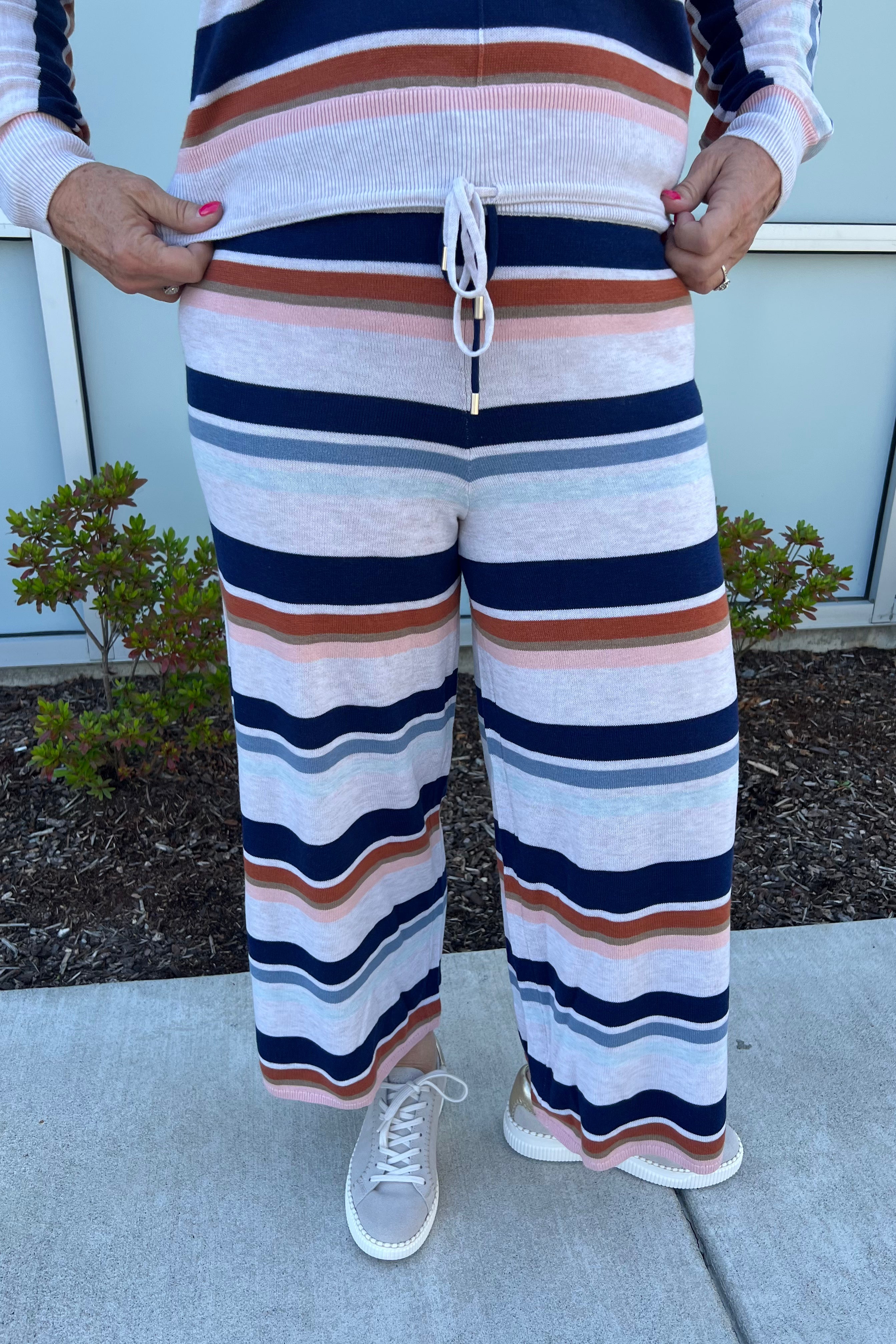 The Polly drawstring pant showcases a delicate lightweight stripe pattern, complemented by long sleeves and a relaxed silhouette, perfect for maintaining comfort during cool winter nights.