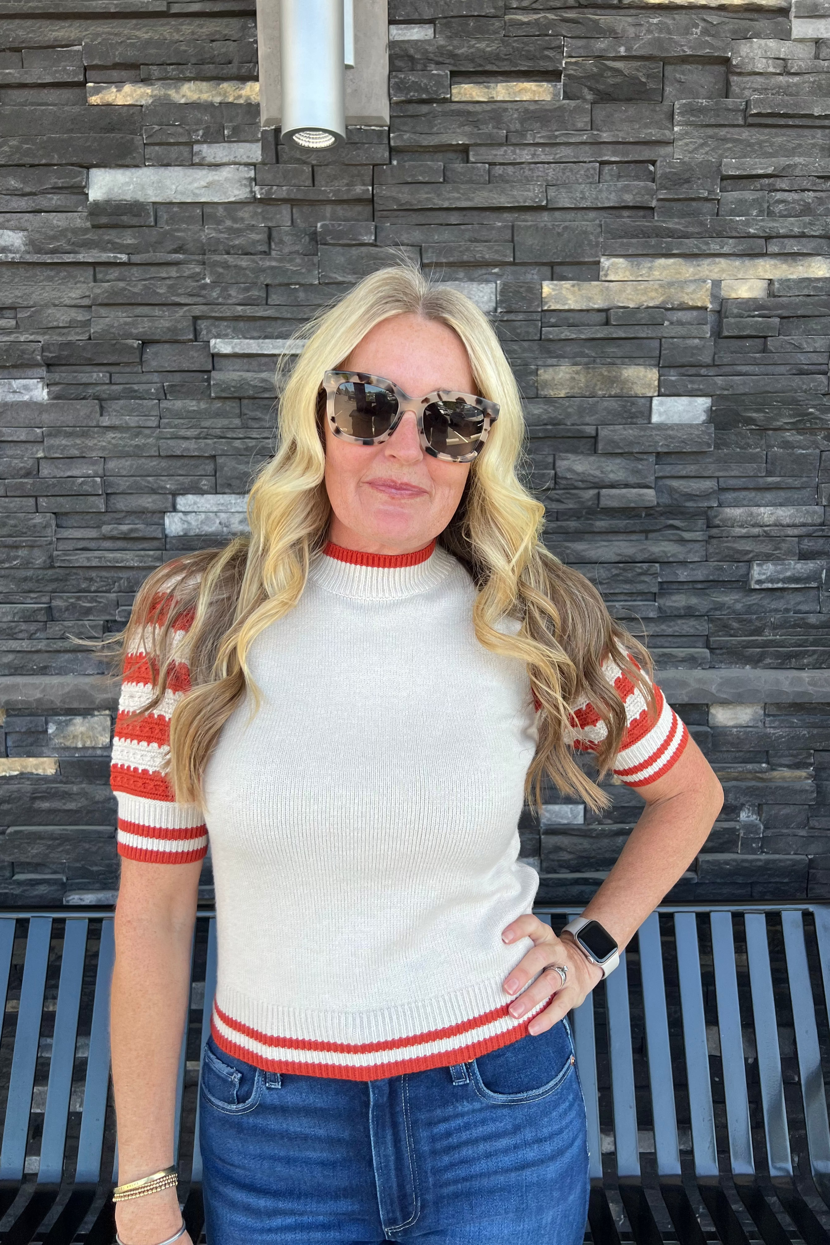 This knit top features puff sleeves and a mock neck, accented with striped sleeves and a charming stripe detail at the waist. It pairs effortlessly with your preferred denim jeans or shorts for a polished look.