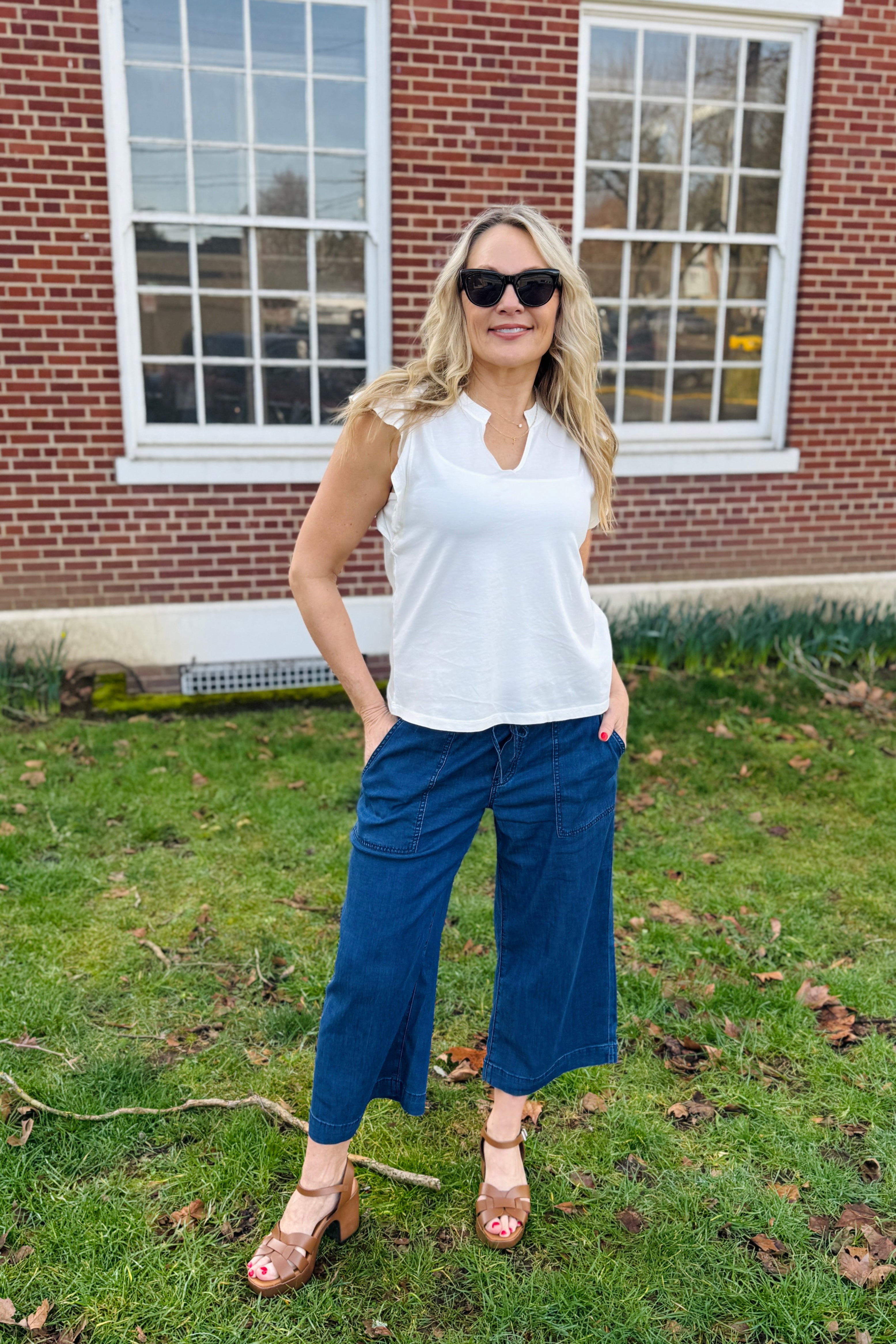 Such feminine details on this top with a stunning open collar and stunning ruffle sleeves. We would wear this to brunch with friends or just out and about on a nice spring day.