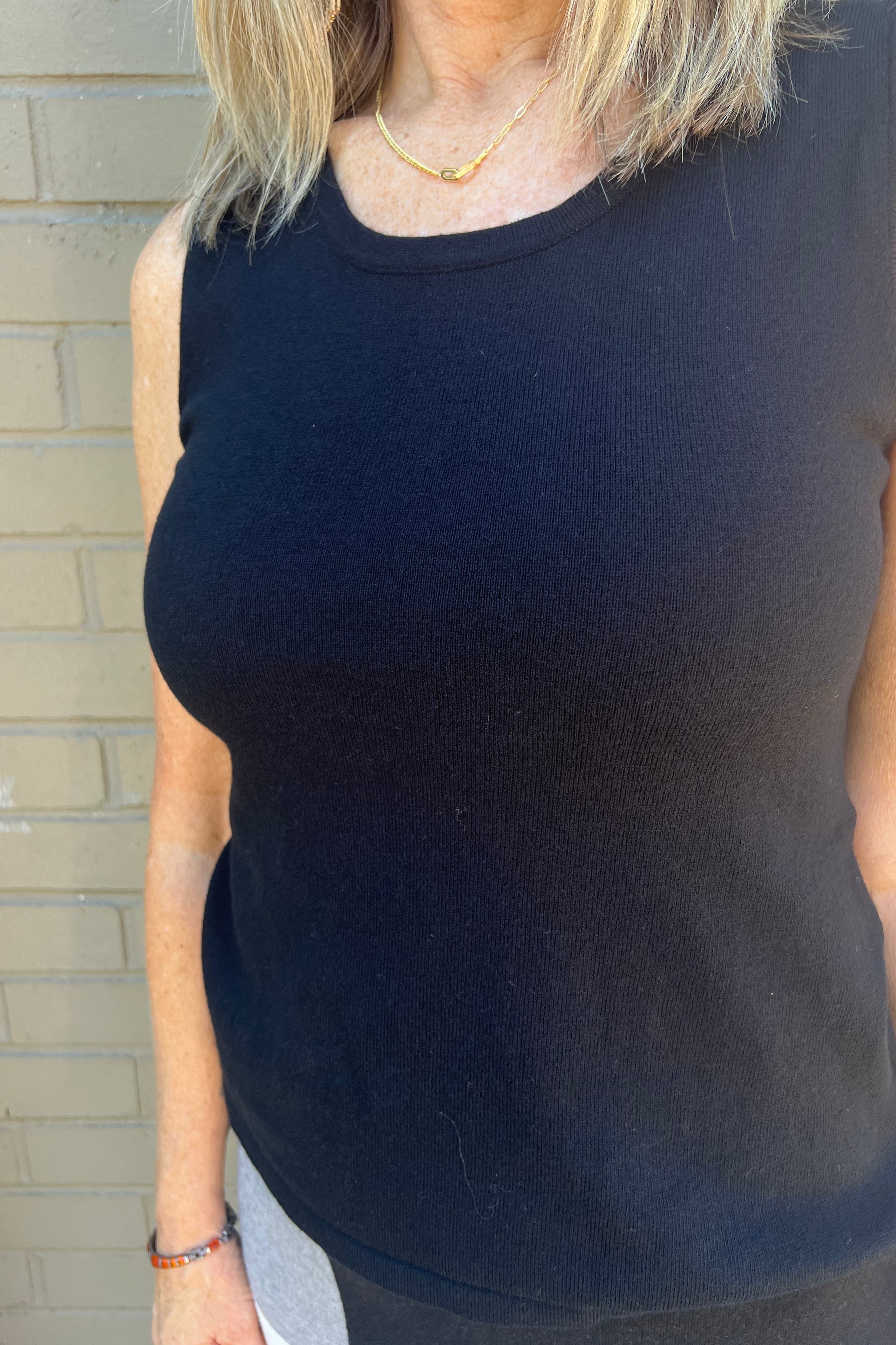 This stylish layering essential features delicate side slits, an ultra-soft fabric, and a classic scoop neckline for refined comfort and versatility. Scoop neck and Side slits