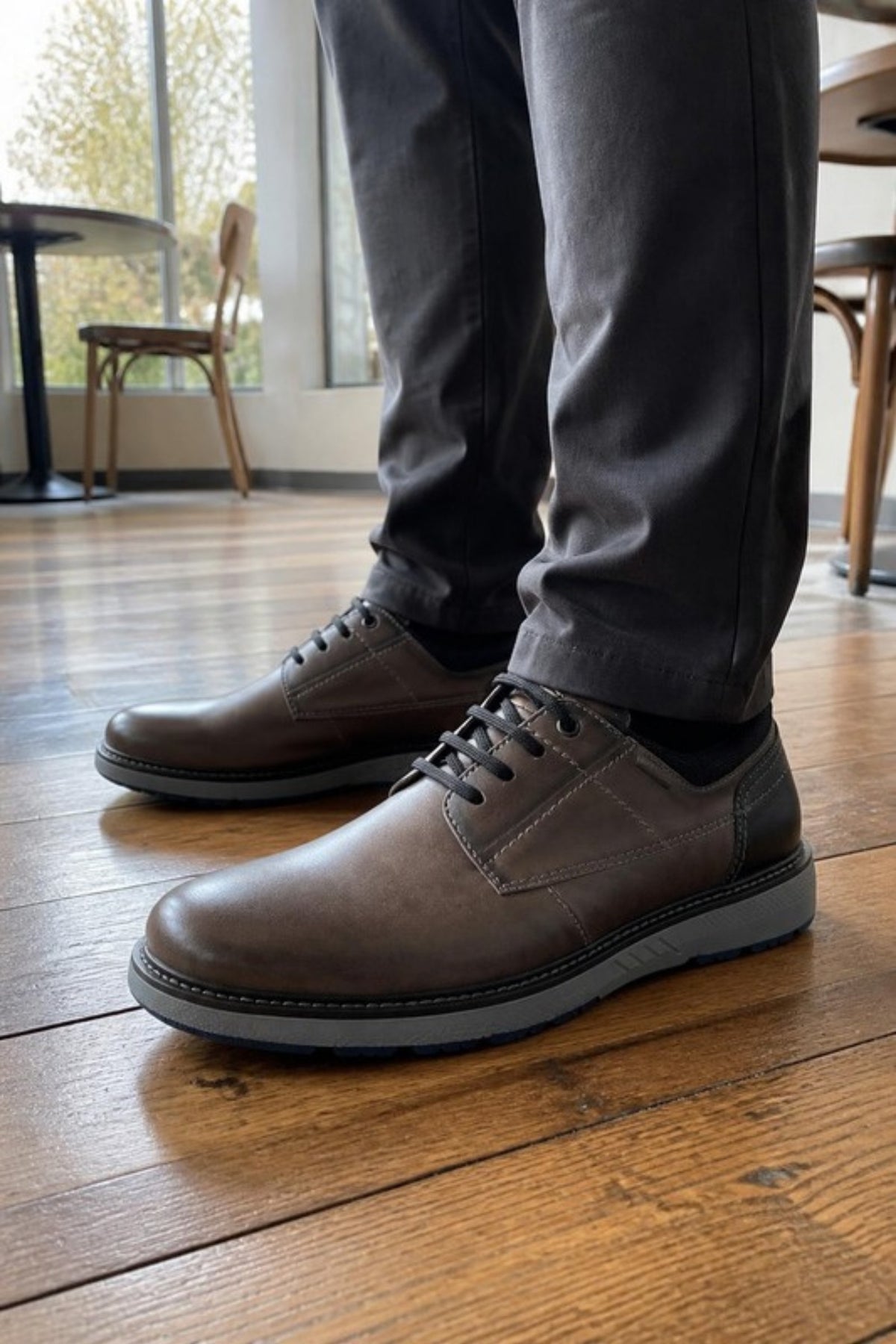 Pikolinos Bilbao shoe in Dark Grey leather with an ultra-light grey sole, worn with charcoal chinos in a coffee shop, a comfortable modern lace-up with a cushioned removable insole for the office, travel days, dinners out and dressing up weekend jeans