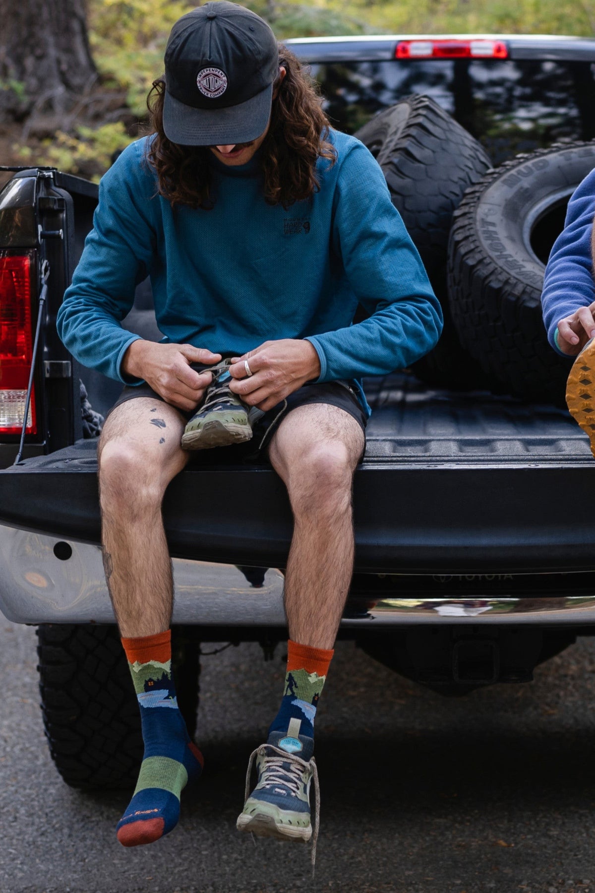 Darn Tough Men's Close Encounters Micro Crew Midweight Hiking Socks in Eclipse worn outdoors, a midweight cushioned merino hiking sock with a Bigfoot scene for hikes, camping and everyday wear with boots, a fun gift for outdoorsmen, guaranteed for life