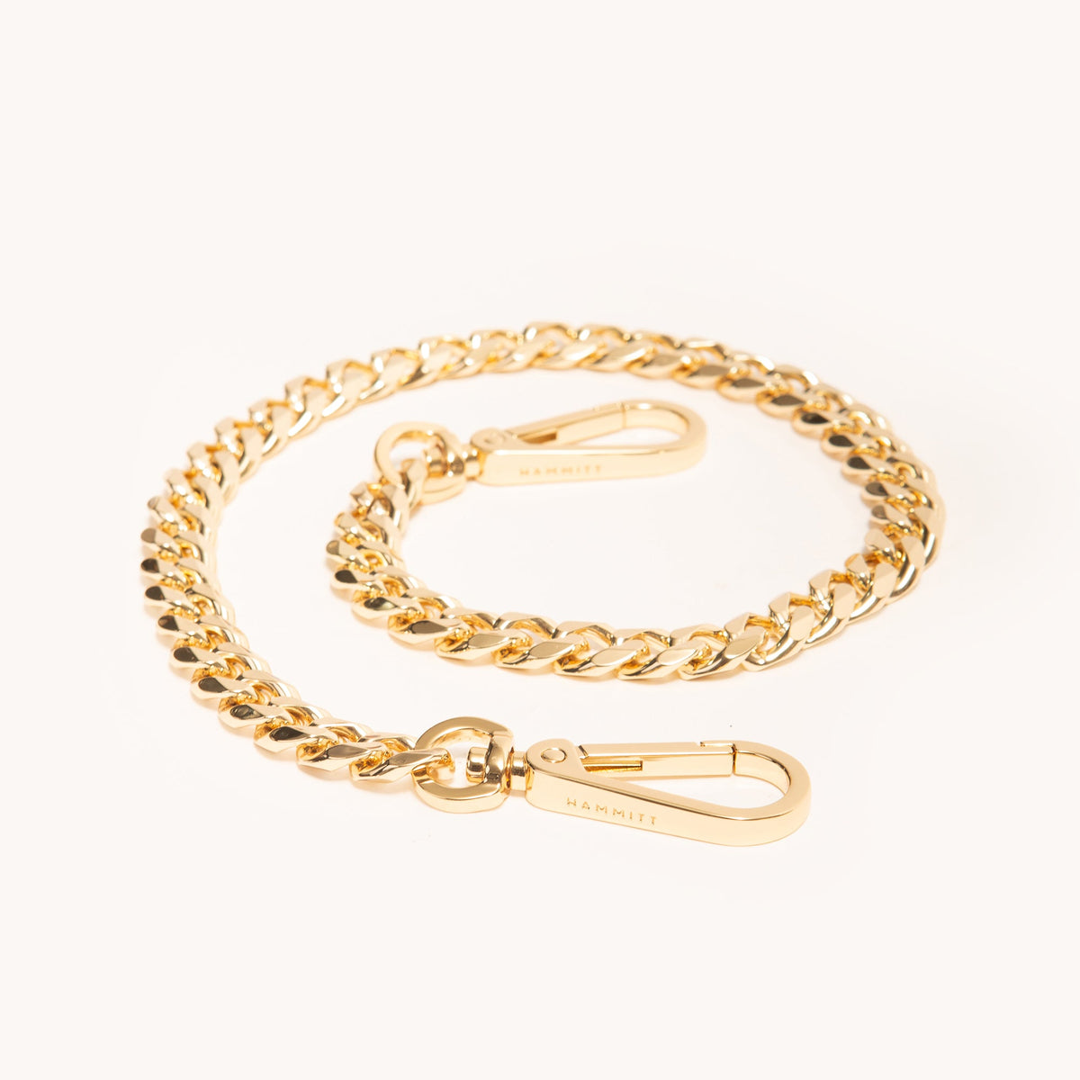 Hammitt Metal Chain Shoulder Strap in Gold coiled, showing the chunky curb links and clasps that attach to Hammitt bags