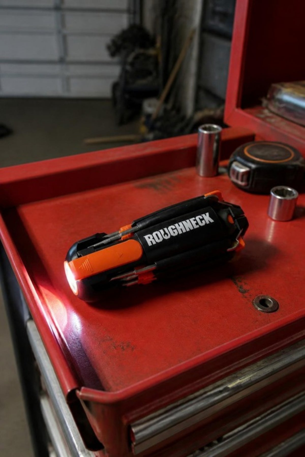 Roughneck 8 in 1 multi tool with its LED on in the toolbox tray, a screwdriver with every bit stored in the handle for car repairs, garage projects and fixes around the house, a practical gift for the handyman in your life