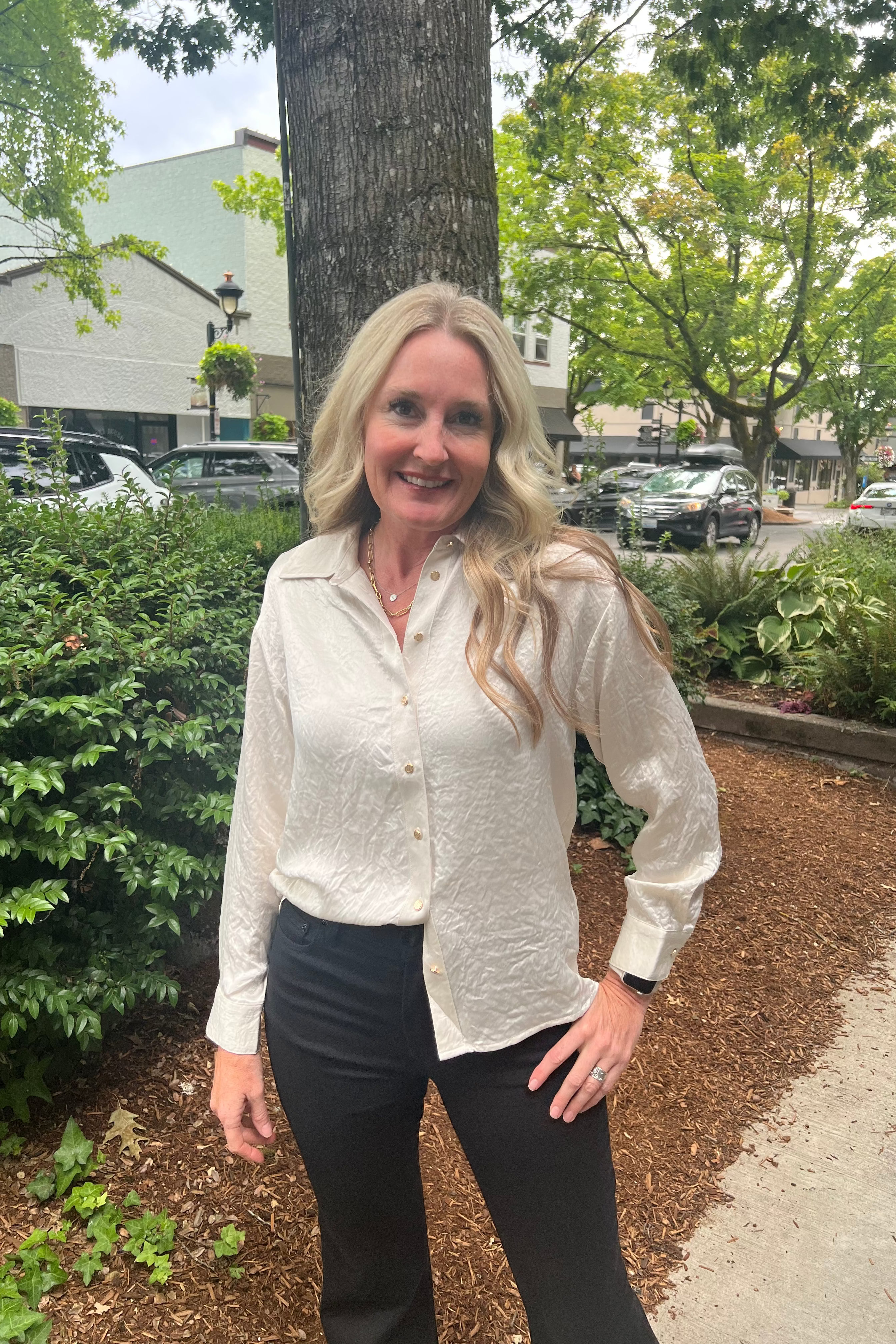 This long-sleeve blouse is crafted from 100% acetate, featuring cuffed sleeves and charming gold button accents. Its distinctive crinkled fabric adds a stylish texture, combining elegance with a modern touch.