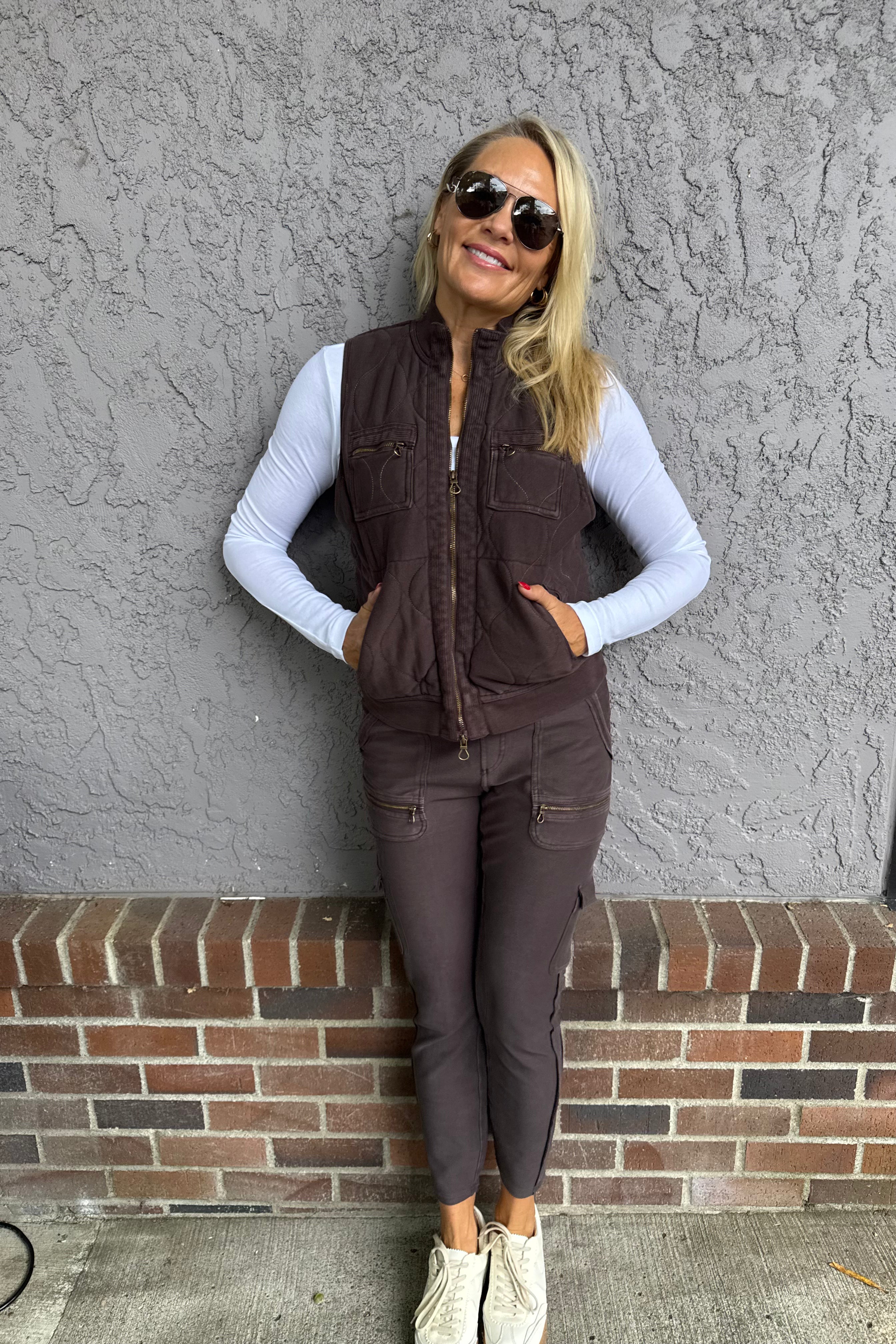 The Aeric Quilted Vest features plush cotton quilting that adds a cozy, homespun charm to your wardrobe. Its two-way zipper allows versatile styling and easy adjustment, while four thoughtfully placed pockets enhance both practicality and appeal. This vest combines comfort and functionality with a refined design, making it a smart choice for layering in cooler weather.