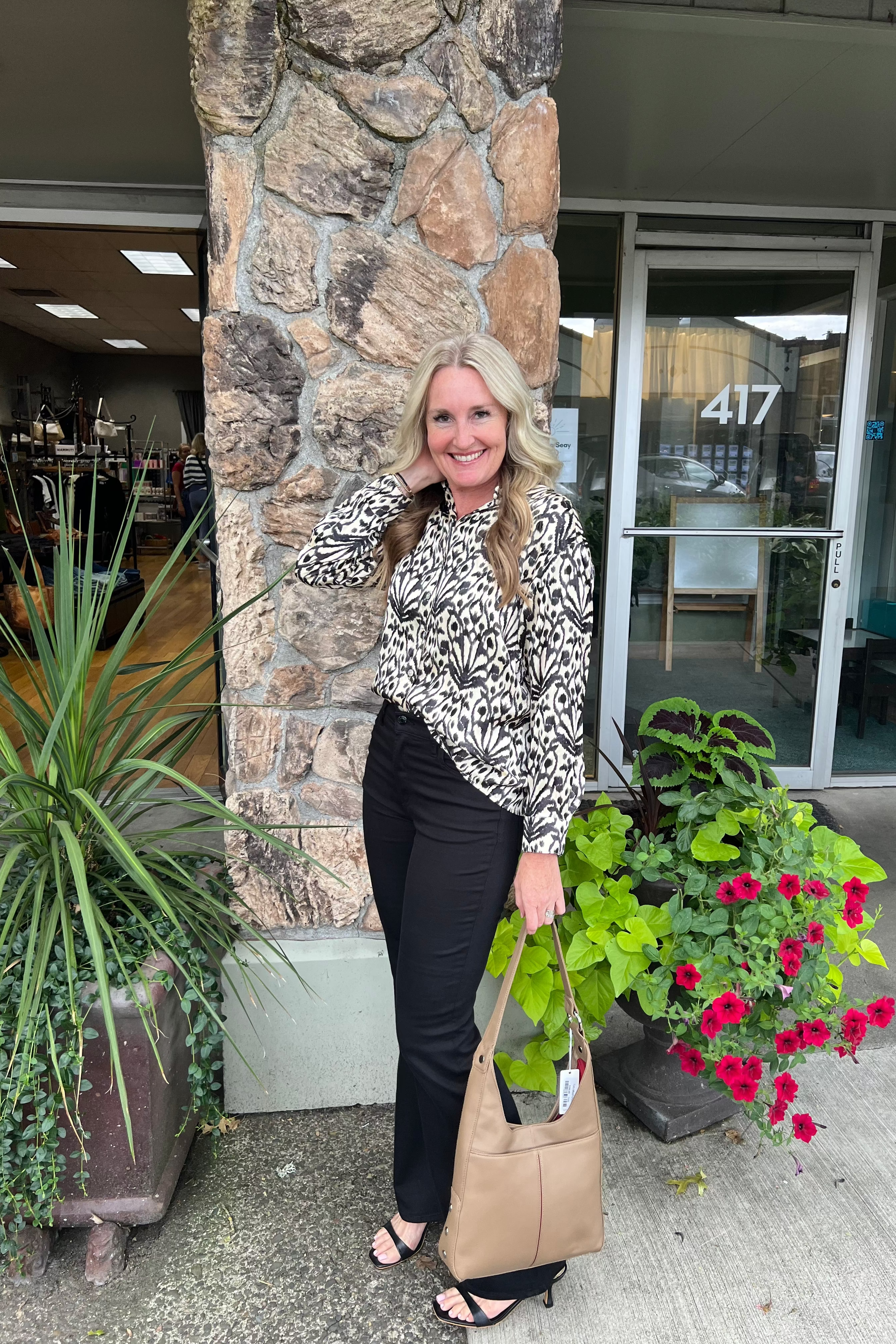 This long-sleeve oversized blouse features a silky texture and a flawless button-front design with a classic collar. Its elegant black and cream print pairs effortlessly with denim, tailored pants, or skirts for a polished look.