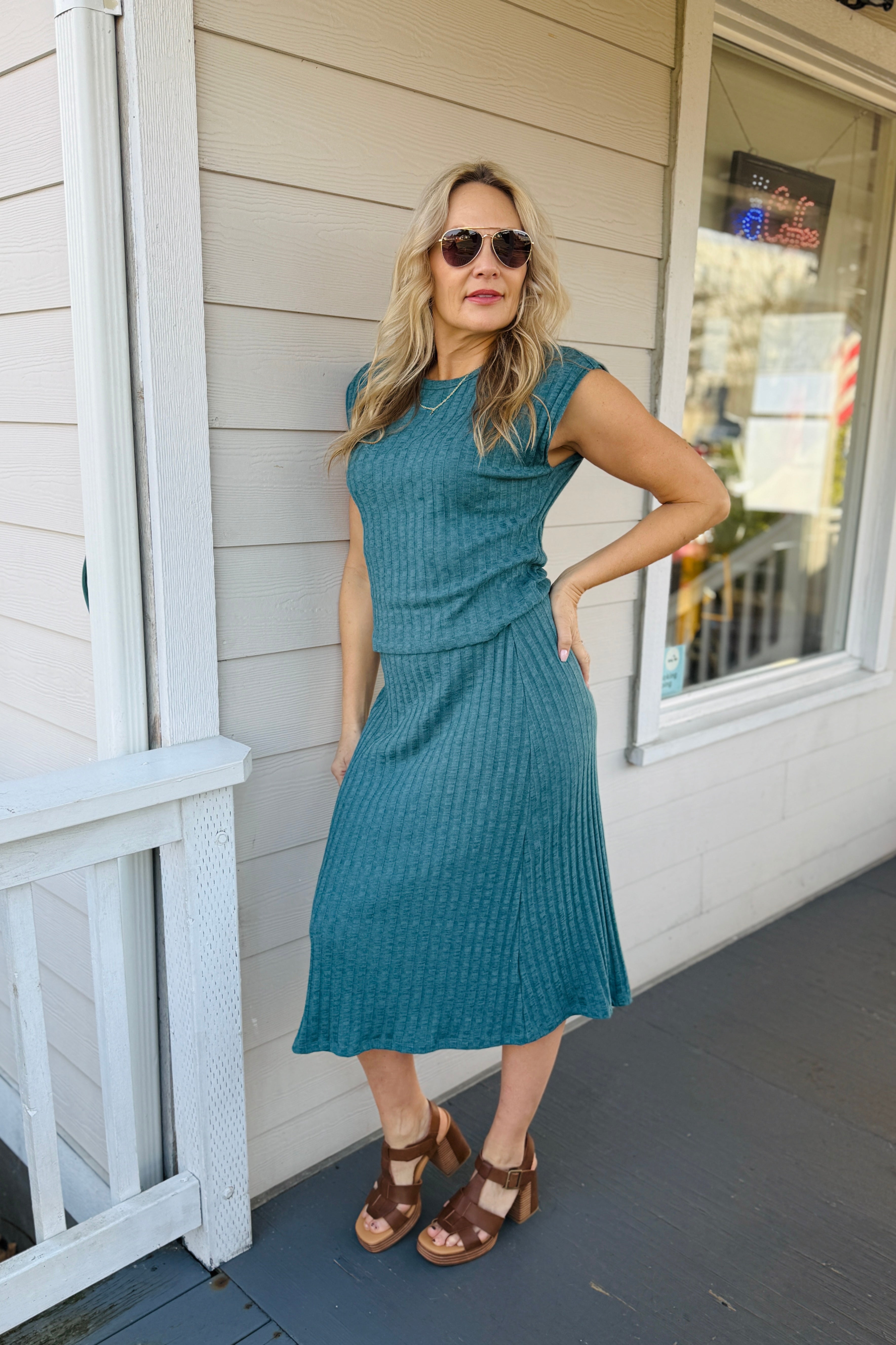 Jinny Power Shoulder Top Structured ribbed fabric meets contemporary silhouette in this essential layering piece. The cap sleeves create a refined shoulder line while the fitted bodice delivers a polished, intentional look. Versatile enough for elevated casual wear or professional settings, this top pairs seamlessly with tailored trousers, midi skirts, or premium denim. The ribbed texture adds visual interest and ensures a flattering fit that moves with you throughout the day.