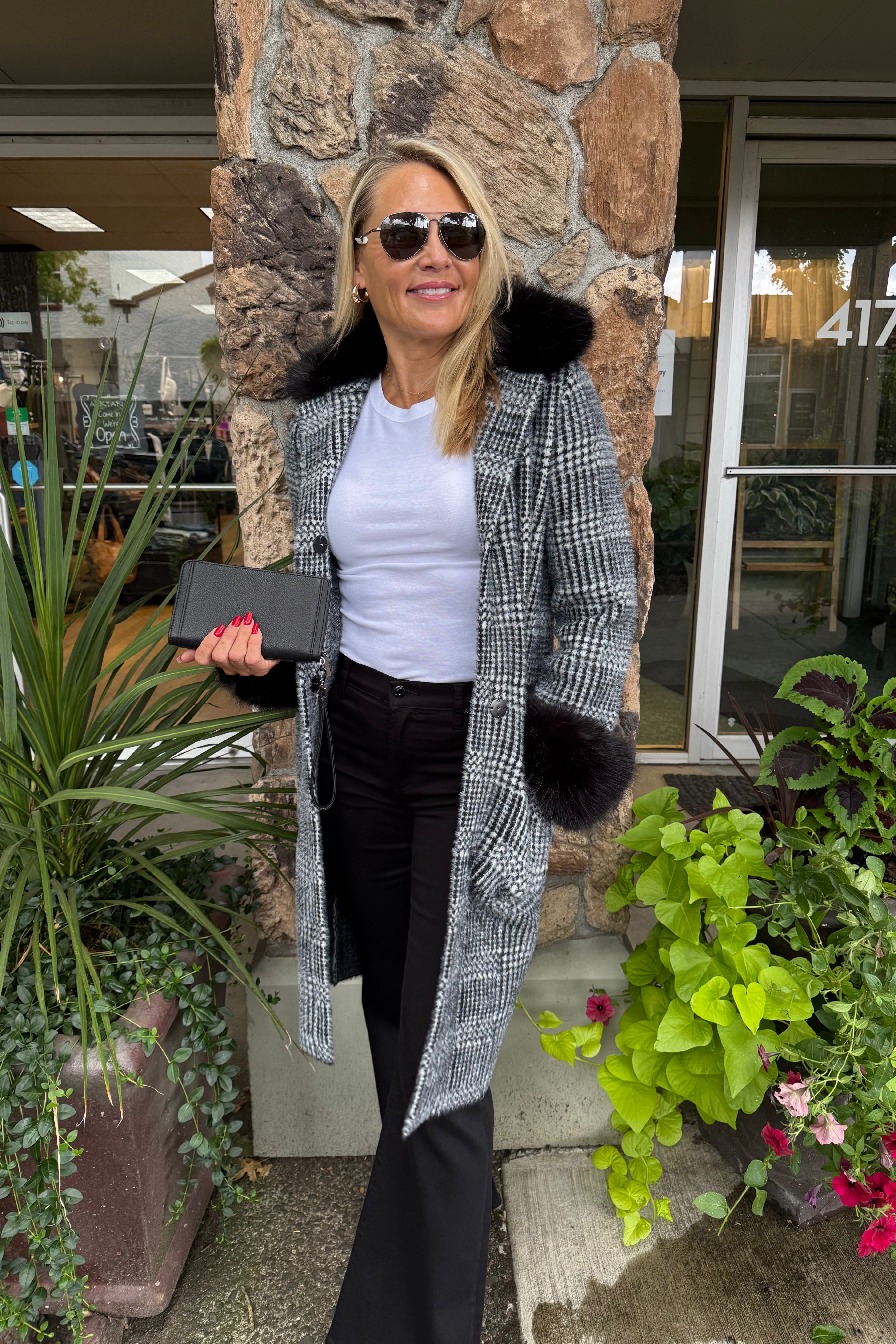 This timeless plaid coat receives a luxurious update with faux fur trim at the collar and cuffs, adding a touch of elegance to its classic design. Crafted from a soft and cozy feather yarn sweater knit, it features a notched collar, front pockets with contrasting trim, and a flattering straight silhouette. A perfect blend of sophistication and comfort for the cooler seasons.