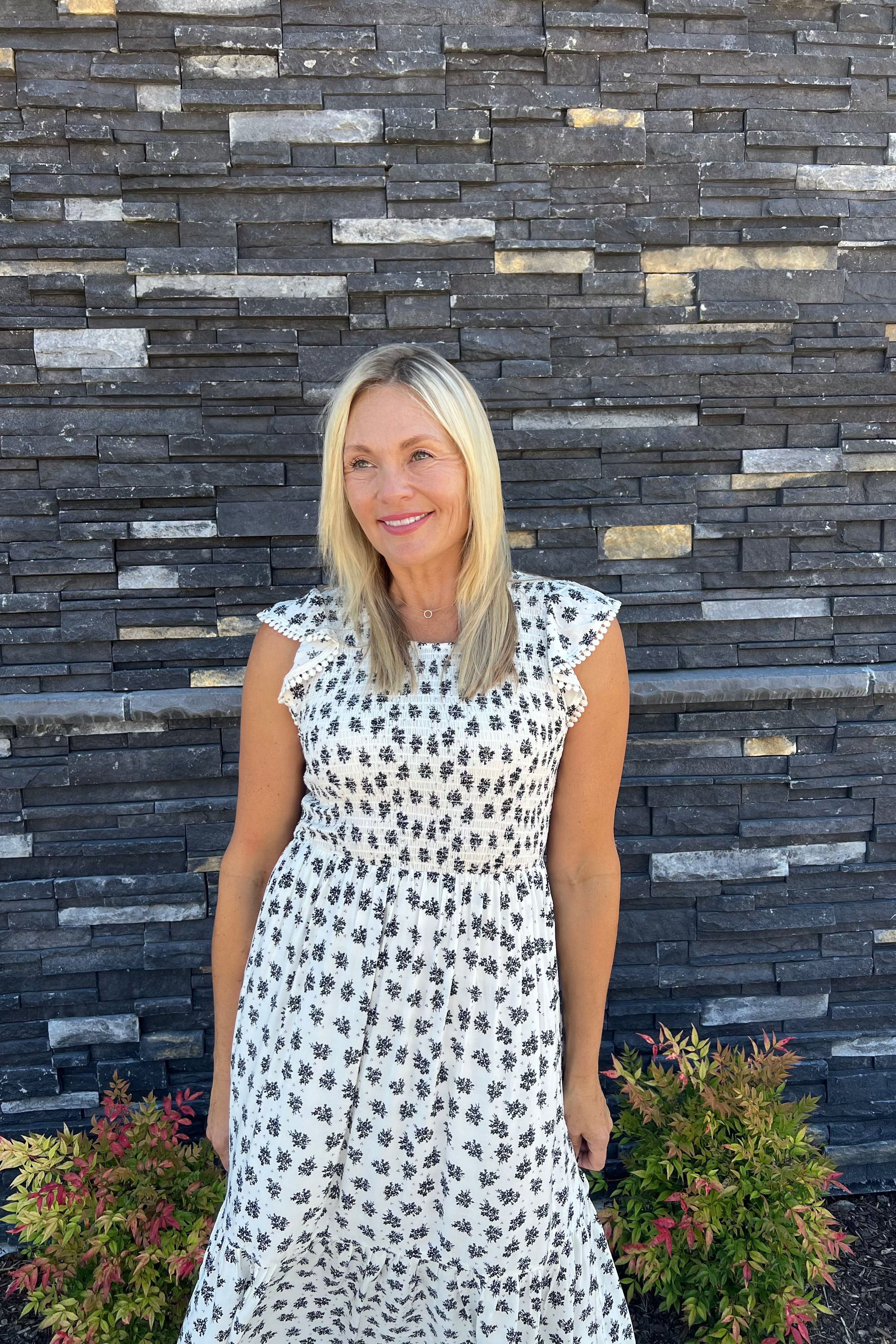 This printed smocked dress, with its smocked bodice and ruffle sleeves, offers a perfect summer look in a flattering midi length. Layer it with a denim jacket for added warmth during cooler nights.