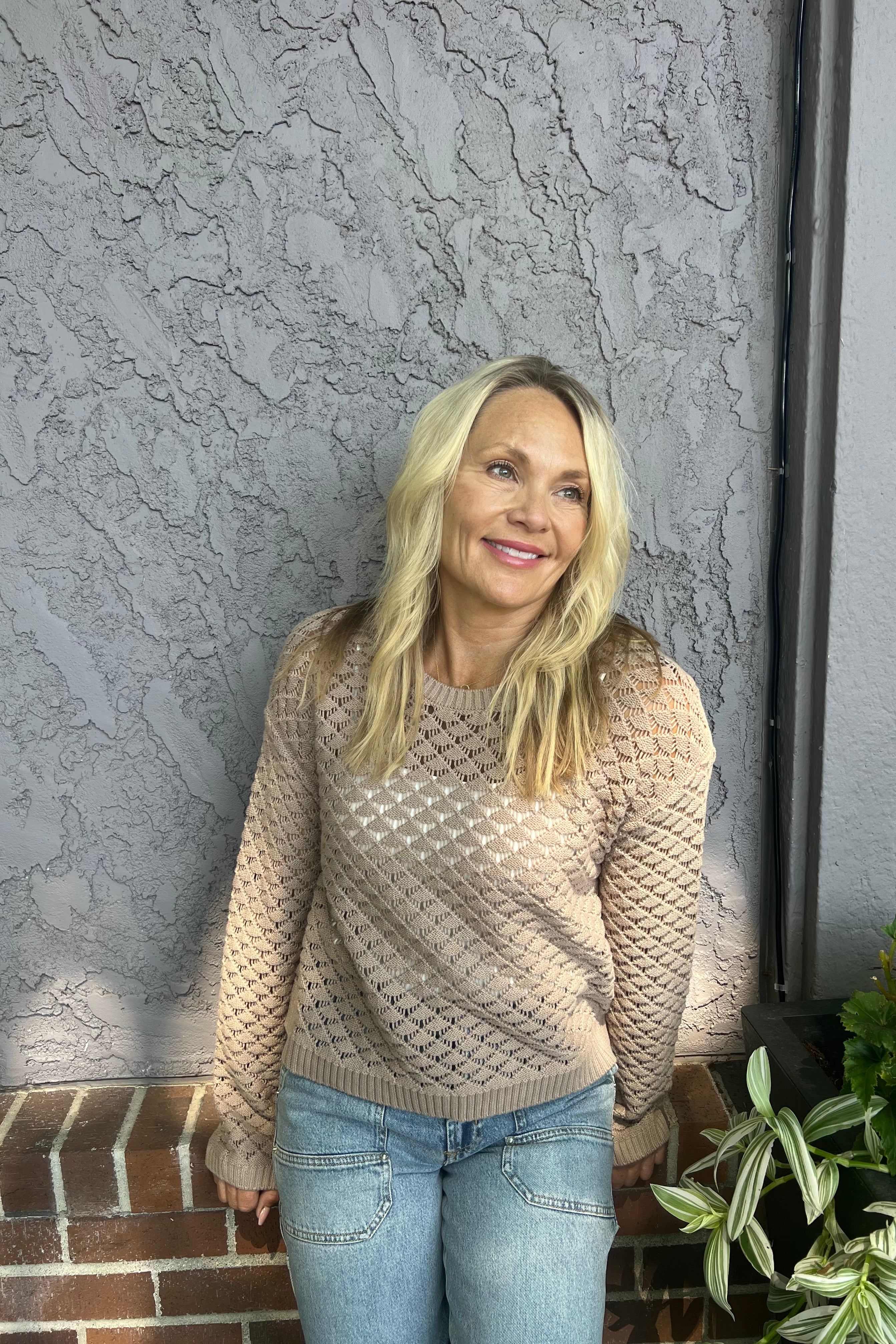 This pullover features a relaxed knit design with a crew neckline. It offers a gentle texture and a subtly sheer finish, making it an excellent choice for late summer and transitional seasons.