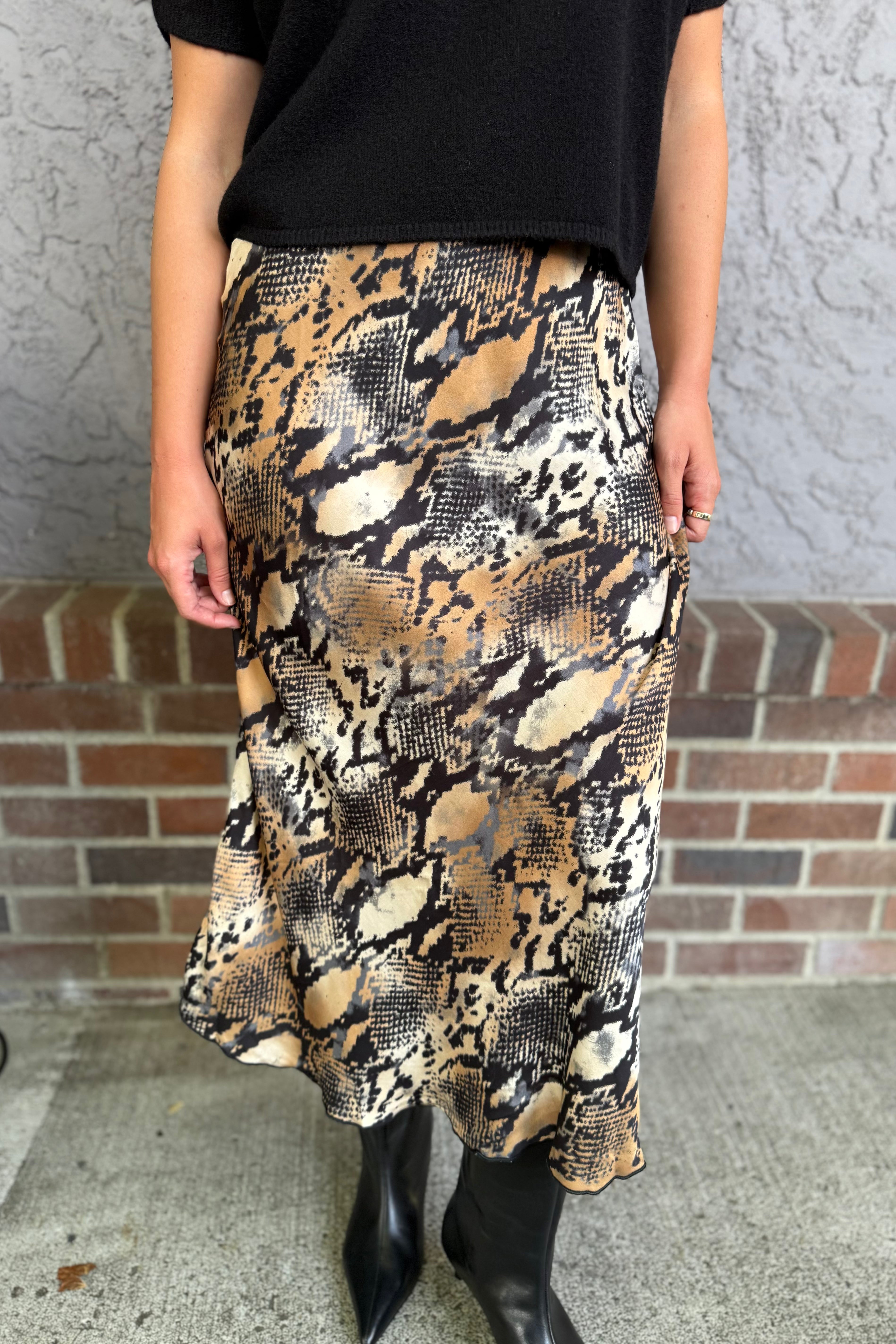 Elevate your style with this silky long skirt, featuring a striking digital snake print in rich camel tones. Designed to drape effortlessly, the smooth, lustrous fabric flows with every step, offering a sleek silhouette and modern edge. The camel snake pattern adds a touch of wild sophistication, making this skirt a standout piece for both day and night looks. Pair it with a fitted top or oversized sweater for effortlessly chic styling