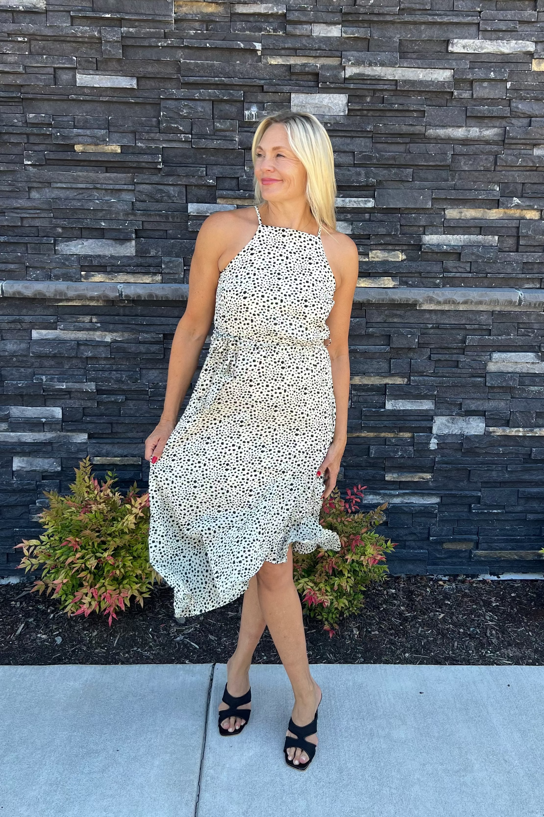 This charming spotted print dress features delicate spaghetti straps and a side tie, complemented by a playful ruffle along the hem. Versatile enough to dress up or down, it promises to make a striking impression wherever you go.