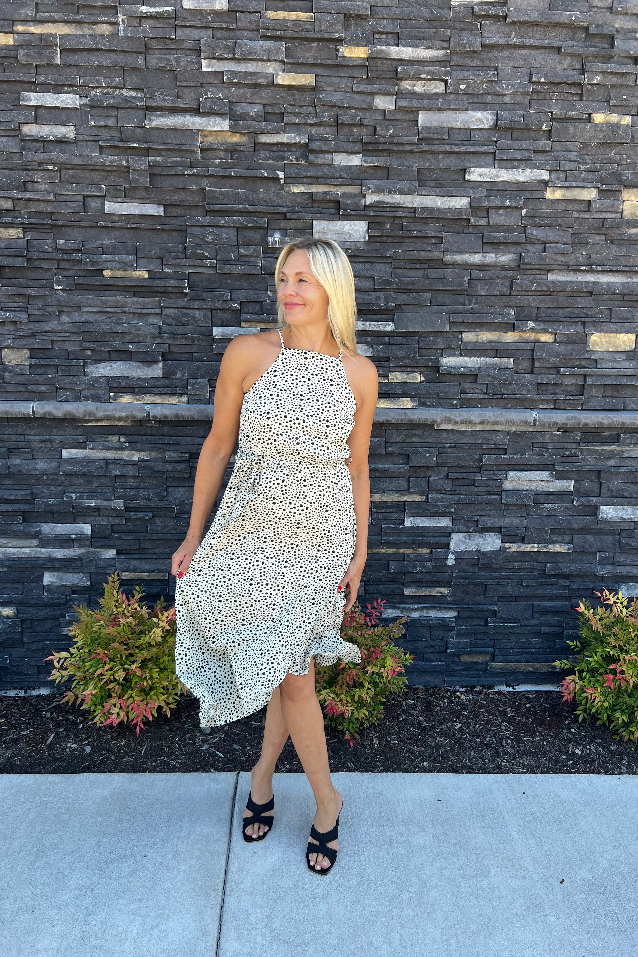 This charming spotted print dress features delicate spaghetti straps and a side tie, complemented by a playful ruffle along the hem. Versatile enough to dress up or down, it promises to make a striking impression wherever you go.