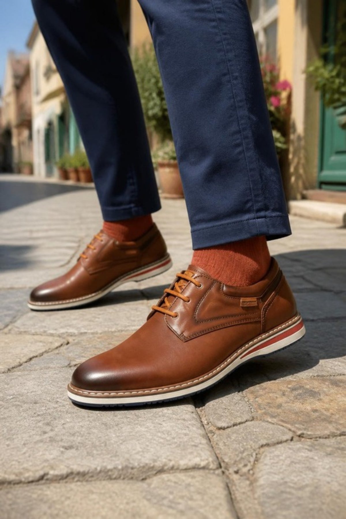 Pikolinos Avila dress shoe in Cuero burnished brown leather with a contrast welt sole, worn with navy chinos and rust socks on an old-town street, a soft, cushioned lace-up that dresses up or down for the office, weddings, date night and weekend jeans