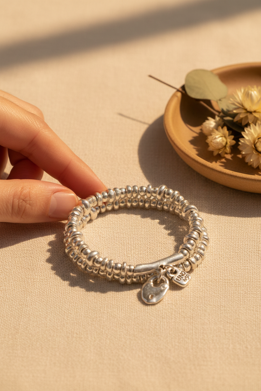 UNO de 50 Beaded Stretch Bracelet in Silver styled on cream linen with dried florals, perfect for stacking, everyday wear and gifting