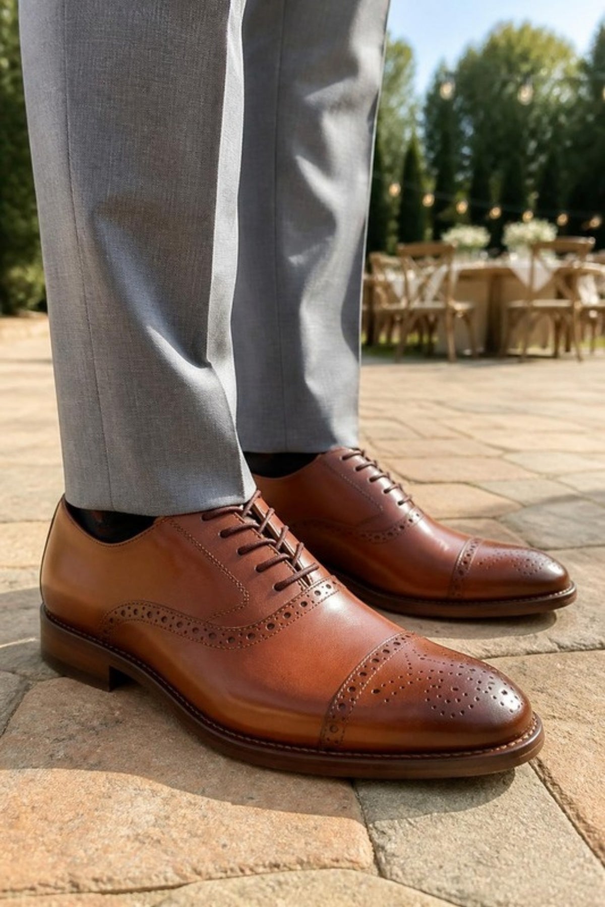 Johnston & Murphy Conard 2.0 cap toe oxford in Tan leather with brogue detailing, worn with light grey suit trousers at an outdoor wedding, a classic dress shoe with cushioned TRUFOAM comfort for weddings, the office, date nights and special occasions