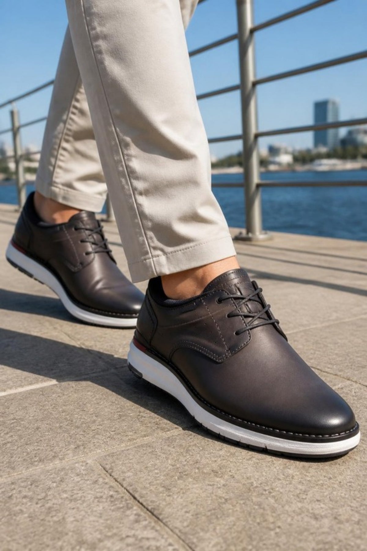 Pikolinos Manacor shoe in Dark Grey leather with an extra-light white sole, worn with stone chinos on a sunny waterfront walk, a comfortable, versatile lace-up for travel days, city walking, casual Fridays and summer weekends