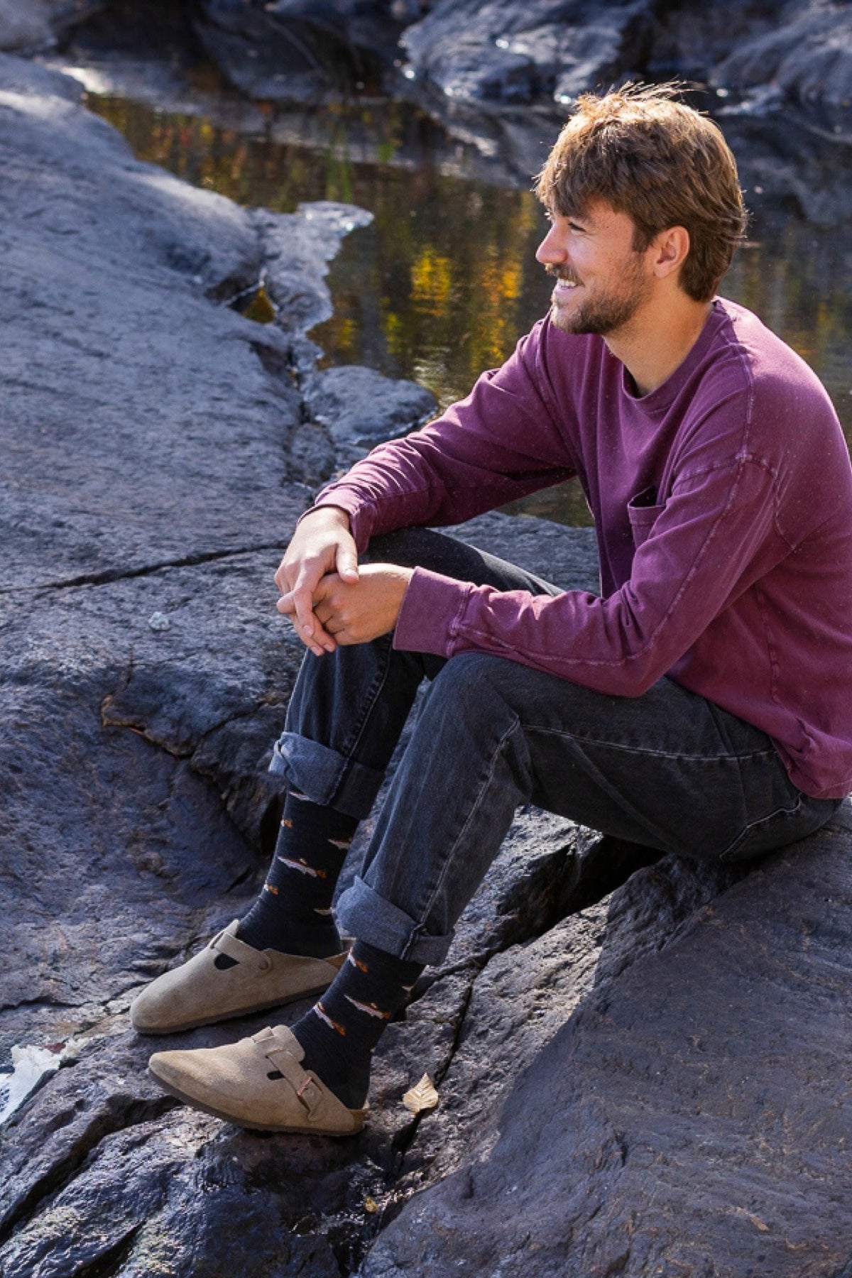 Darn Tough Men's Spey Fly Crew Lightweight Lifestyle Socks in Charcoal worn outdoors, a trout-pattern merino crew sock for anglers, fishing trips and everyday wear with boots or sneakers, a great gift for fly fishermen, guaranteed for life