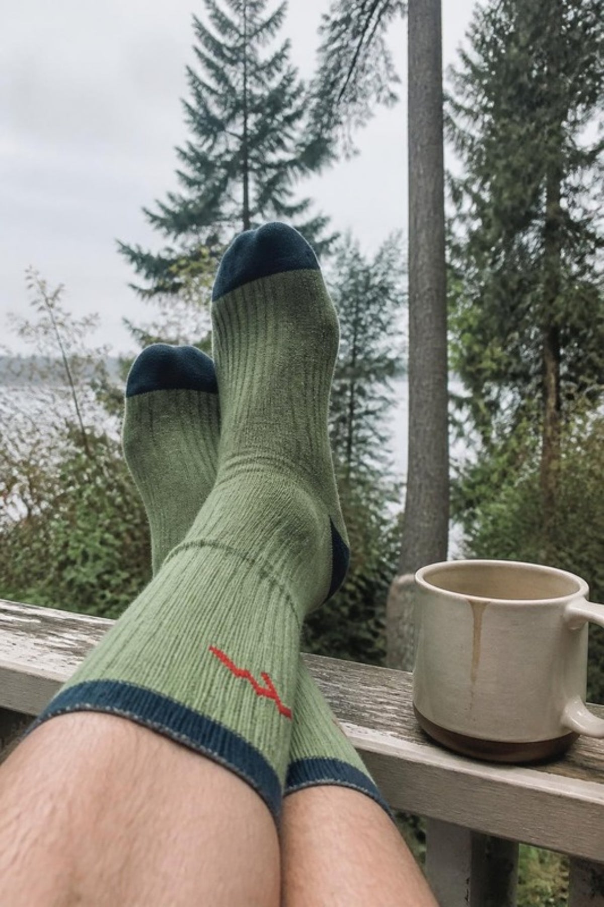 Darn Tough Midweight Micro Crew Hiker Socks in Willow worn with feet up on a cabin porch, cozy cushioned merino socks for hiking, cabin weekends and cool Pacific Northwest mornings, guaranteed for life