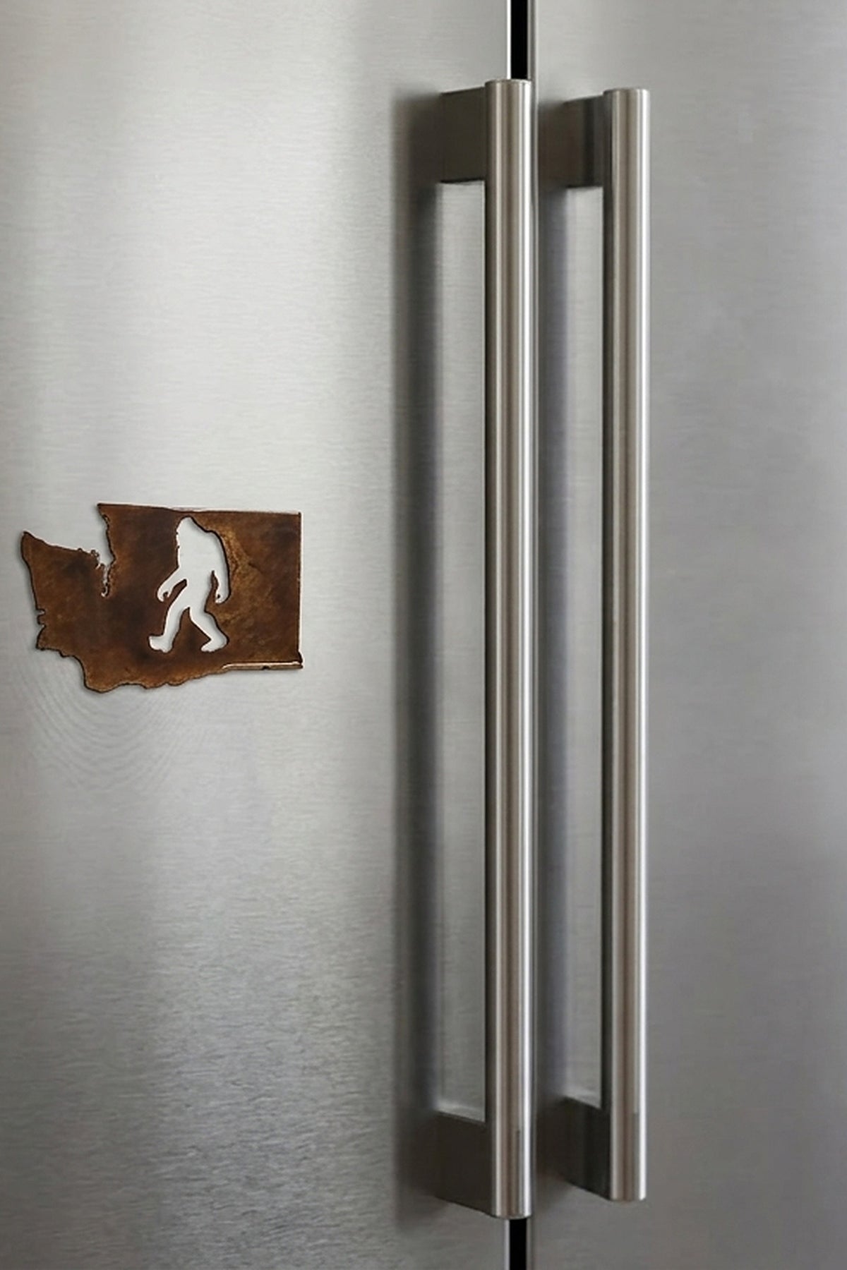 Paradise Cay Publications Washington Bigfoot magnet on a stainless fridge, a fun Washington state Bigfoot magnet for the kitchen and an easy gift for Washington locals and visitors