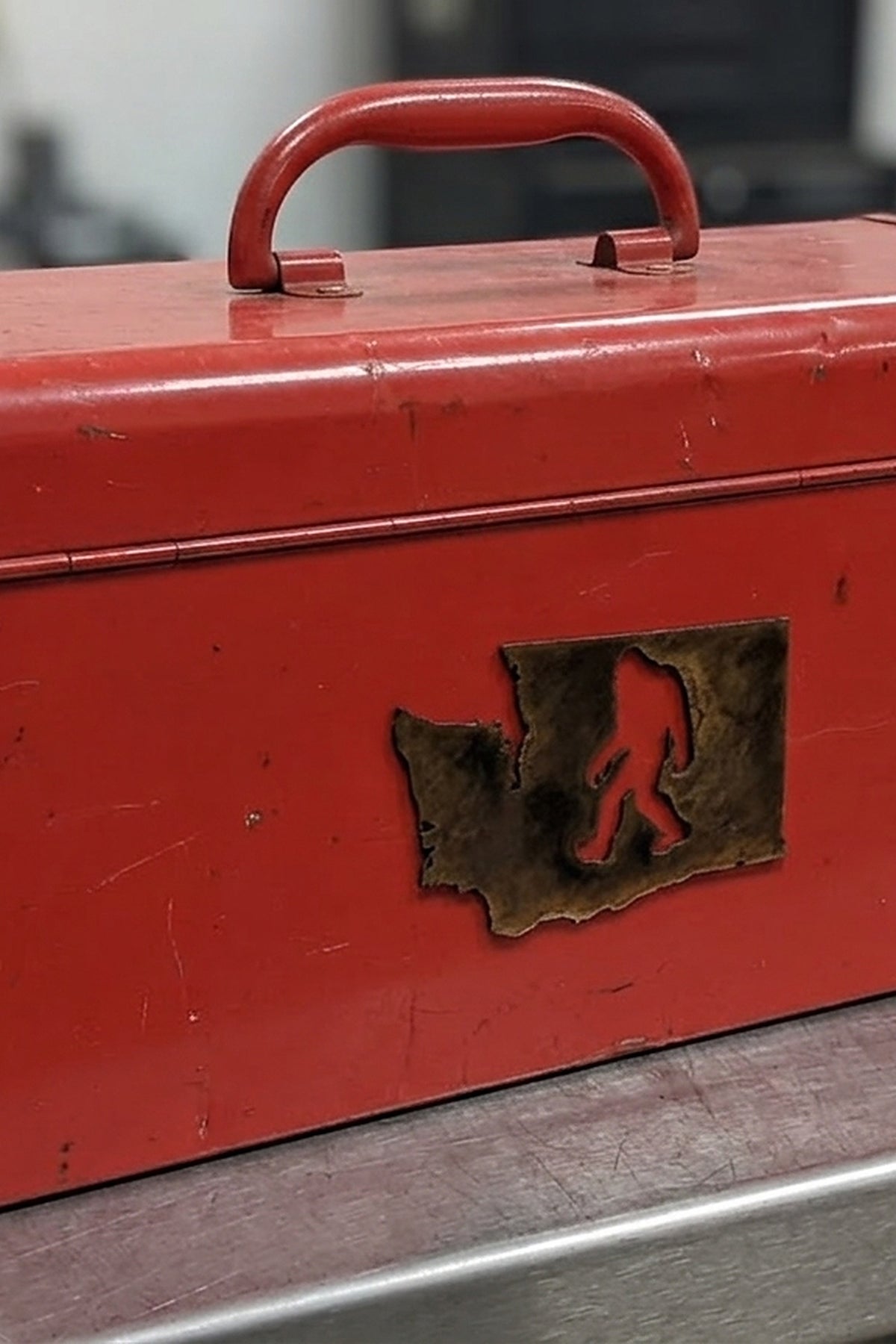 Paradise Cay Publications Washington Bigfoot magnet on a red toolbox, a rusted steel Washington state magnet with a Bigfoot cutout for the fridge, toolbox or truck, a great Pacific Northwest souvenir
